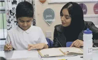  ??  ?? Teacher Khansa Ali with a child at Parkinson Lane Primary School, Halifax