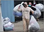  ?? AILEEN WINGBLAD — MEDIANEWS GROUP ?? Volunteers haul bags of donated coats and jackets to a charity group’s waiting van.