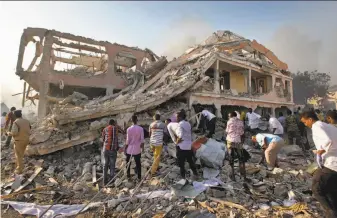  ?? Farah Abdi Warsameh / Associated Press ?? Somalis search for survivors in a building shattered by a truck bomb in the capital of Mogadishu. Security forces had been trailing the truck after it had raised suspicions.