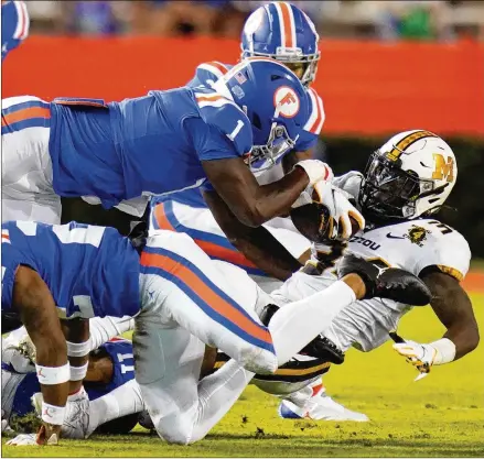  ?? JOHN RAOUX/ASSOCIATED PRESS ?? Florida linebacker Brenton Cox Jr. (1) and defensive back Brad Stewart Jr. combine to bring down Missouri running back Larry Rountree III during the first half Saturday night in Gainesvill­e. Cox ranks fourth on the team with 21 tackles.