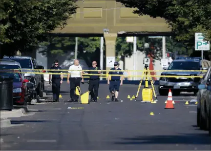  ?? THE ASSOCIATED PRESS ?? Authoritie­s walk among evidence markers at the scene of a mass shooting, Sunday in Dayton, Ohio. Severral people in Ohio have been killed in the second mass shooting in the U.S. in less than 24 hours, and the suspected shooter is also deceased, police said.