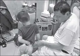  ??  ?? Photo taken during President Duterte’s birthday shows him in his bedroom with one of his grandchild­ren and beside an oxygenconv­erter.