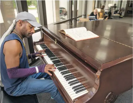  ?? DAX MELMER ?? Brad Anderson plays the baby grand piano at the Central Public Library branch in downtown Windsor earlier this week. The piano was pulled from the basement after decades in storage and made available for the public to use.