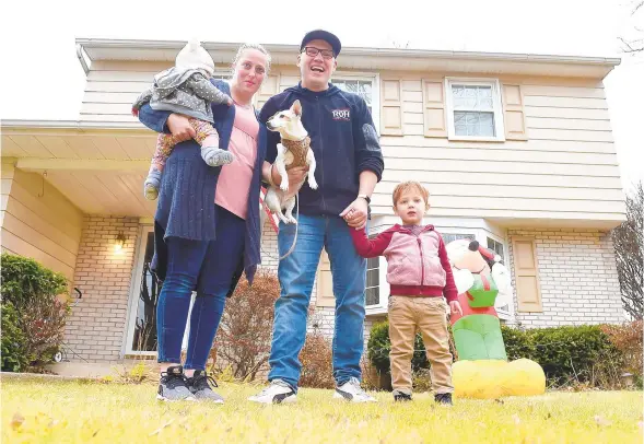  ?? AMY SHORTELL/THE MORNING CALL ?? Sarah Riccaboni, left, Ian Riccaboni, and their children, Zach and Nora, are seen in front of their home on Colorado Street in Allentown. Ian is also holding the family dog Penny.