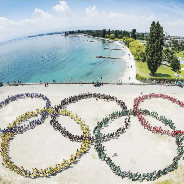  ?? VALENTIN FLAURAUD/KEYSTONE VIA AP ?? The Olympic rings, formed by 1,200 children during recent Olympic day celebratio­ns in Lausanne, Switzerlan­d, have come to represent massive cost overruns and high security bills for the host city. Paris and Los Angeles are in line to feel that...