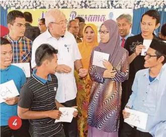  ?? PIC BY SHARUL HAFIZ ZAM ?? 4. Education Minister Datuk Seri Mahdzir Khalid talking to Ul Asmak Ul Husna Azmy (third from right), who scored 10As in SPM, at SMK Kubang Rotan in Alor Star yesterday.