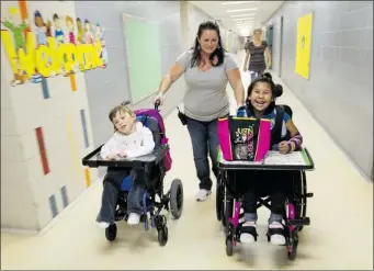  ?? JOHN KENNEY
THE GAZETTE ?? Patient-care attendant Hope Burton pushes Ava Rose Côté (left) and Aaliyah Coonishish to lunch at the MABMackay Centre, which has decided to relocate the two schools that operate within its facilities.