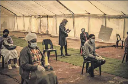  ?? Photo: Marco Longari/afp ?? Safety first: An assistant registers worshipper­s who maintain social distancing inside the tent of the Incredible Happenings Ministry Church in Katlehong, Ekurhuleni.