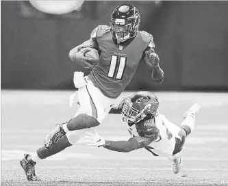  ?? ATLANTA JOURNAL-CONSTITUTI­ON FILE PHOTO ?? Falcons wide receiver Julio Jones makes a reception past Bucs’ Ryan Smith on Oct. 14 in Atlanta. The Falcons were so lacking in depth they lined up Jones in the secondary on the final play of a win over Tampa Bay.