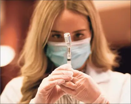  ?? Jessica Hill / Associated Press ?? A pharmacist readies a syringe of a COVID-19 vaccine from Johnson & Johnson and Janssen Pharmaceut­icals on Wednesday at Hartford Hospital.