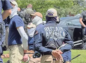  ?? GEORJI BROWN/AP ?? Authoritie­s arrest members of the white supremacis­t group Patriot Front near an Idaho pride event Saturday after they were found packed into the back of a U-Haul truck with riot gear.