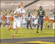  ?? Walt Unks The Associated Press ?? Clemson QB Trevor Lawrence scores against Wake Forest in a solid performanc­e for the Tigers as they beat the Demon Deacons.