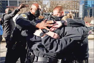  ?? Mark Humphrey / Associated Press ?? Nashville Police Chief John Drake, left, joins a group of police officers as they embrace after speaking at a news conference on Sunday in Nashville, Tenn. The officers are part of a group of officers credited with evacuating people before an explosion took place in downtown Nashville early Christmas morning.