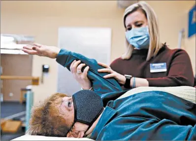  ?? STACEY WESCOTT/CHICAGO TRIBUNE PHOTOS ?? Kimi Smith, a physical therapist at Athletico, works with Joyce Brodsky on strengthen­ing exercises for her shoulder and rotator cuff on Dec. 14 in Niles. Brodsky injured her shoulder in September.