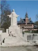  ??  ?? Achter het monument van de oorlogssla­chtoffers zien we de herdenking­swand en het gemeentehu­is.