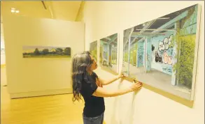  ?? Matthew Brown / Hearst Connecticu­t Media ?? Tracy McKenna assists in the hanging of works by Valeri Larko and fellow artist Linda Kuehne for the upcoming show “Spaces of Uncertaint­y” being presented at Greenwich Library’s Flinn Gallery.