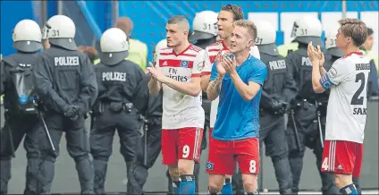  ??  ?? Lewis Holtby, con lágrimas, y otrs jugadores del Hamburgo agradecen el apoyo de la afición tras consumar el descenso FOTO: EFE