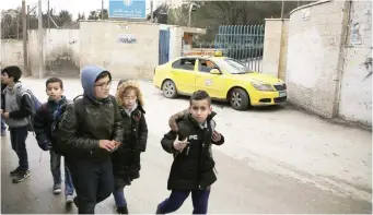  ??  ?? Palestinia­n boys walk past a UN-run school in the Qalandia refugee camp near Ramallah in the West Bank. (AFP)