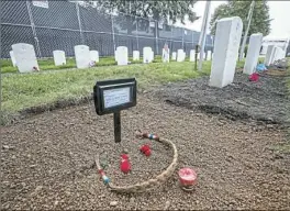  ?? Charlies Fox/Philadelph­ia Inquirer ?? Sweetgrass, tobacco bundles and a candle lie where one of the Northern Arapaho children was disinterre­d from the Carlisle Barracks Indian Cemetery. The Army officially passed the custody of the Arapaho students on to the tribe on Monday.