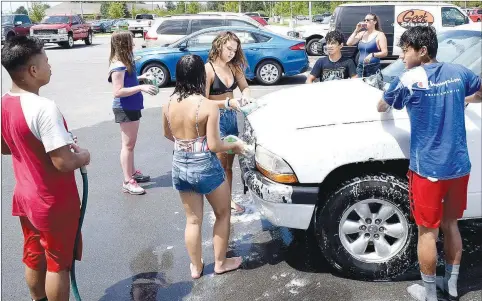  ?? Westside Eagle Observer/MIKE ECKELS ?? Several members of the Decatur High School cheer team enjoy time together as the team holds a car wash at McLarty Daniels Ford in Bentonvill­e in August 2019. Events like this one are now forbidden due to the coronaviru­s outbreak.