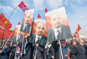  ?? NATALIA KOLESNIKOV­A/GETTY-AFP ?? Marking Lenin’s birth: Russian Communist Party members and supporters carry portraits of Vladimir Lenin on Thursday in Moscow as they walk toward the mausoleum of the revolution­ary leader and Soviet state founder for a flower-laying ceremony marking the 151th anniversar­y of his birth.