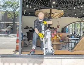  ?? AP ?? Efectos. Un operario arregla la vidriera de un local en Minneapoli­s.