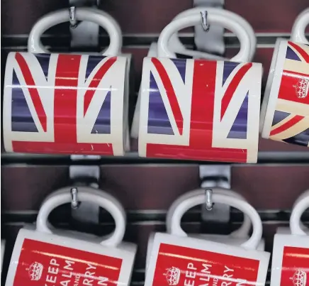  ??  ?? > Tourist mugs for sale in London. Calls are growing for Theresa May to soften her Brexit stance or suspend the process