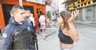  ?? JOSE LUCENA / ESTADÃO CONTEÚDO ?? Mulher ensanguent­ada fala com policial militar após os tiroteios ocorridos na manhã de ontem