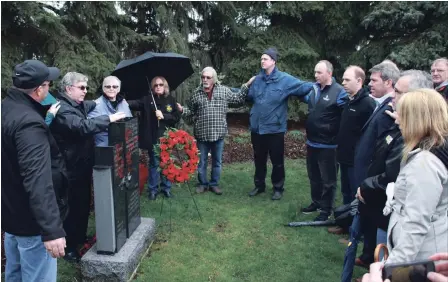  ?? LAURA BARTON THE WELLAND TRIBUNE ?? People Saturday gather at Merrit Park in Welland around the monument to individual­s killed at work at for a National Day of Mourning ceremony.