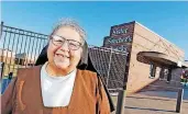  ?? [PHOTO BY NATE ?? Sister Stephanie Sanchez stands near the snack bar that bears her name at Bishop McGuinness High School’s Pribil Stadium in Oklahoma City.