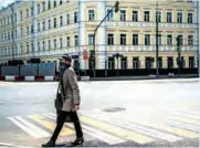  ?? (AFP) ?? A woman wearing a protective face mask walks across a street in Moscow recently.