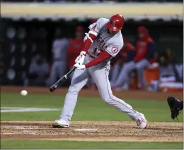  ?? JED JACOBSOHN – THE ASSOCIATED PRESS ?? The Angels’ Shohei Ohtani hits a single during the fifth inning of Tuesday’s game at Oakland. Ohtani also homered and picked up his 10th victory of the season on the mound.