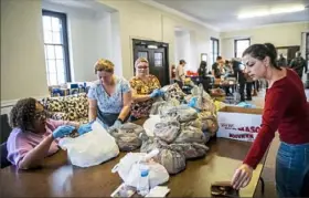  ?? Pittsburgh Post-Gazette ?? From left, Marylin Williams, of Coraopolis, Tammi Chamberlin, Melissa Chamberlin and Danielle Bair, all of Moon, pack up prepared Thanksgivi­ng meals to be delivered to senior citizens Thursday at Coraopolis United Methodist Church in Coraopolis.