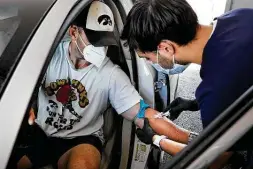  ?? Bob Owen / Staff photograph­er ?? Jacob Gaier, a medical assistant with Remedy, a telemedici­ne company, takes a blood sample from Blake Anderson to test for antibodies.