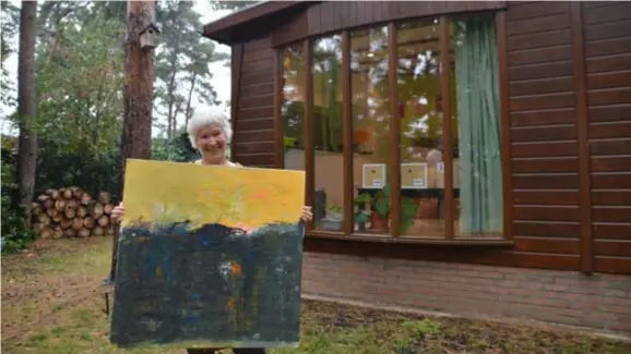  ?? FOTO KRISTIN MATTHYSSEN ?? Marleen Geluykens met haar door corona geïnspiree­rd schilderij. De natuur doet haar deugd in coronatijd.