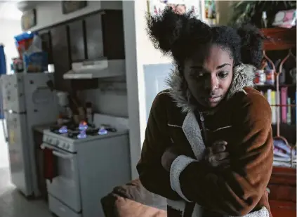  ?? Jon Shapley / Staff photograph­er ?? Shanice Ardion tries to stay warm inside her home Tuesday after losing power at Cuney Homes. She said the stove was her only source of heat. Experts say using a gas stove in such a way is extremely dangerous, as it poses fire and carbon monoxide risks.