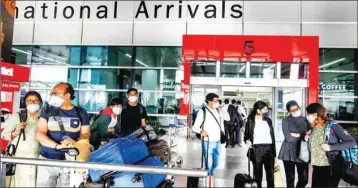  ?? PTI ?? Passengers wear protective face masks in wake of novel Coronaviru­s pandemic at IGI Airport on Sunday