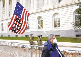  ?? PATRICK SEMANSKY/AP ?? A protester walks past the Russell Senate Office Building on Capitol Hill in Washington on Friday.