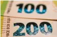  ??  ?? Diese glänzenden Flächen auf den 100 Euro Scheinen und auf den 200 Eu ro Scheinen nennt man Hologramme.