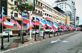  ??  ?? JALUR Gemilang dan bendera Sabah yang dikibarkan di sepanjang Jalan Pantai.