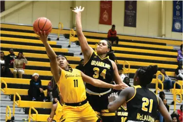  ?? (Pine Bluff Commercial/I.C. Murrell) ?? Tia Morgan of UAPB scoops in a layup in heavy traffic against Amanda Blake (34) and Jurnee McLaurin of Grambling State in the second quarter Monday at H.O. Clemmons Arena.