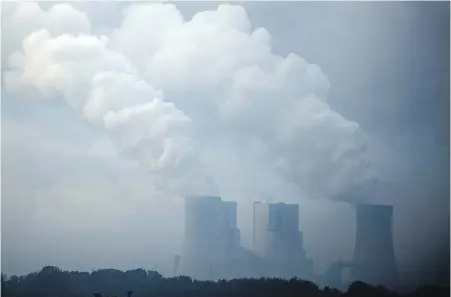  ??  ?? A brown-coal power plant is photograph­ed in morning fog near Hoeningen, Germany.
