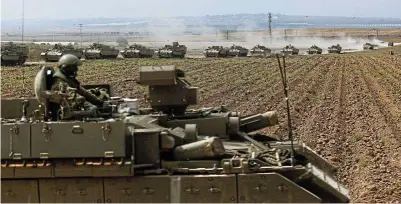  ?? Picture: Amir Levy/Getty Images ?? Tanks move in formation near the border with Gaza yesterday near Sderot, Israel.
