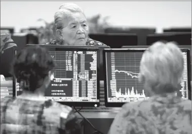  ?? HU GUOLIN / FOR CHINA DAILY ?? Investors check stock prices at a securities brokerage in Jiujiang, Jiangxi province, on June 19.