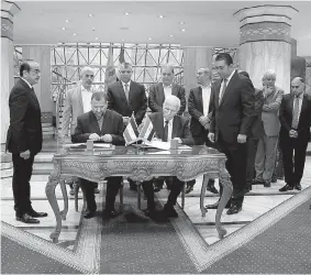  ?? AP Photo/Nariman El-Mofty ?? Senior Fatah official Azzam al-Ahmad, center right, and Hamas’ representa­tive, Saleh al-Arouri, center left, sign a reconcilia­tion deal during a short ceremony Thursday at the Egyptian intelligen­ce complex in Cairo. The signing came after two days of...