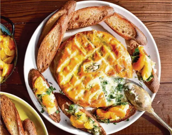  ?? Christian Reynoso/Special to The Chronicle ?? Baked brie, a staple of festive get-togethers, gets a refresh with fresh herbs and a tangy jam made of fresh tangerines cooked with a little sugar and water.