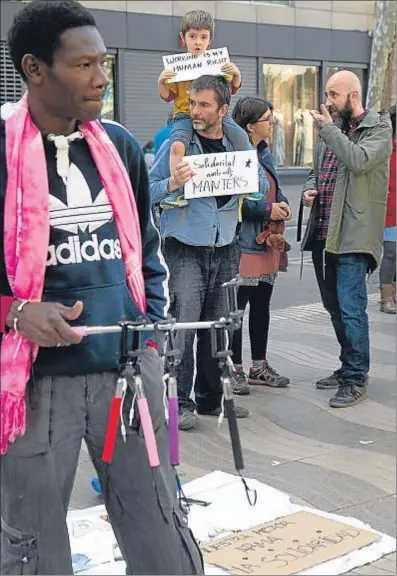  ?? KIM MANRESA ?? El edil de la CUP, Josep Garganté, a la derecha, en el mercadillo protesta que hacen los manteros