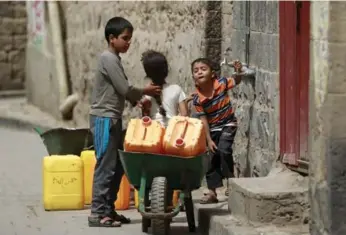  ?? MOHAMMED HUWAIS/AFP/GETTY IMAGES ?? Yemeni children prepare to fill jerry cans with water from a public tap. The capital, Sanaa, is facing an acute shortage of water during Ramadan. Almost 9.4 million Yemenis have little access to water, the UN says.