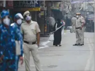  ??  ?? Policemen stand along a road to enforce Covid guidelines at a closed market area during Eid-al-Fitr festival, which marks the end of the holy fasting month of Ramadan, under the coronaviru­s pandemic in the old quarters of New Delhi, yesterday.