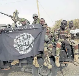  ?? AFP ?? Trofeo. Soldados nigerianos sostienen una bandera de Boko Haram.